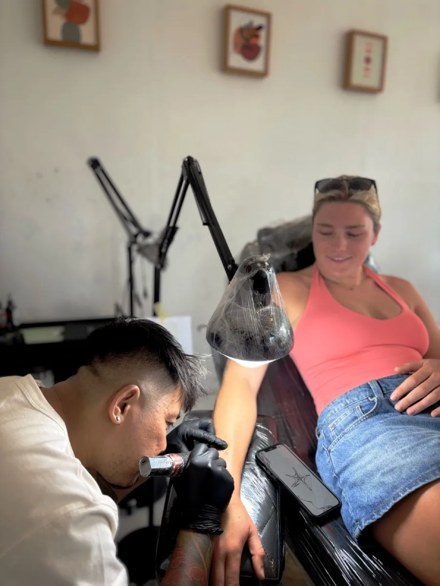 Tattoo artist tattooing client with precision needle in Seminyak